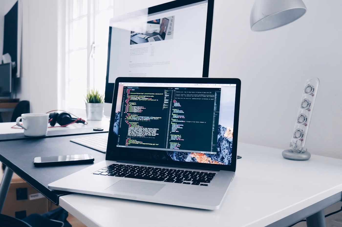 Laptop mit Code-Editor am Arbeitsplatz